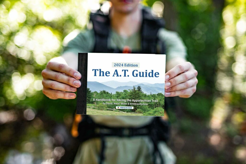 Hiker holding 2024 A.T. Guide